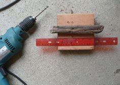 a drill and a piece of wood sitting on the ground