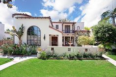 a white house with lots of windows and landscaping