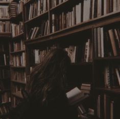 a woman is sitting in front of a bookshelf