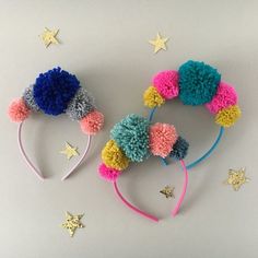 three different colored pom - poms on top of each other with stars around them