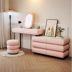 a living room with a pink couch and mirror on the wall next to a table