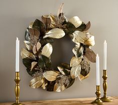 a wreath and two candles on a table