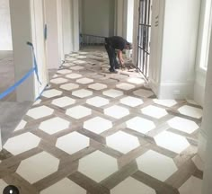 a man is working on the floor in an empty room