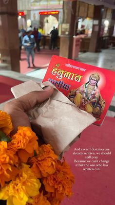 a person holding up a card with flowers in front of them