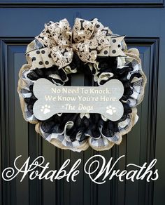 a black and white wreath with a dog's bone on it that says, no need to knock we know you're here the dogs