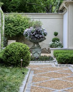 an outdoor garden with stone walkway and potted plants