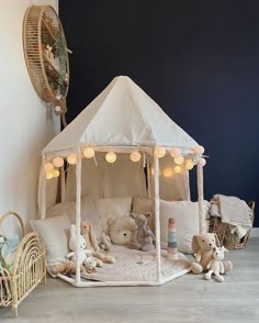 a white tent with teddy bears in it and lights on the ceiling, next to other stuffed animals