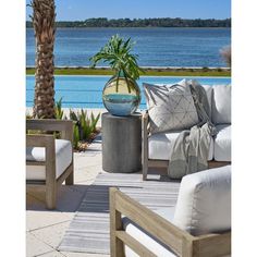 an outdoor living area with chairs, tables and a potted plant on the table