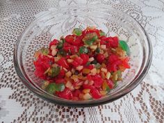 a glass bowl filled with chopped vegetables on top of a table