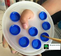 a person holding a plate with blue cups in it