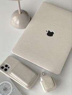 an apple laptop computer sitting on top of a table next to a phone and mouse