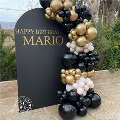 a black and gold balloon arch with the words happy birthday mario on it