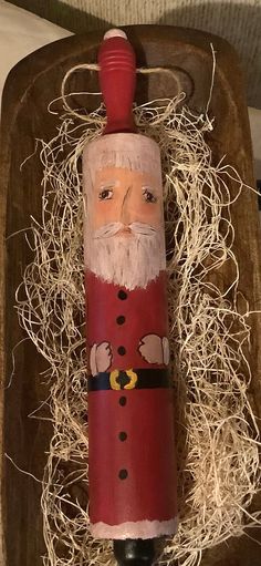 a wine bottle with a santa clause on it sitting in a wooden box filled with straw