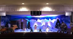 the stage is decorated with snowmen and reindeers in front of a christmas scene