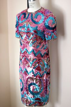 "So fun and so funky!! Vintage 80 sequin/bead hot pink, blue, silver dress! Sooo shiny and sparkly. You will definitely be the center of attention in this unique piece! 100% silk Zips in the back and is in Very good condition! I do not see any sequin loss. Hot pink silk lining Stunning geometric design with beautiful details Measuring: 38\" long Bust: 34\" Waist: 30\" Hip 36\" Pet free/ smoke free Enjoy!" Pink Sequin Fabric For Night Out And Holiday, Pink Sequin Fabric For Holiday And Night Out, Pink Glitter Dress For Party Season, Pink Glitter Dresses For Party Season, Pink Sequin Dress With Glitter For Holidays, Pink Sequin Glitter Dress For Evening, Holiday Pink Sequin Dress With Glitter, Pink Sequin Glitter Dress For Holiday, Pink Glitter Sequin Dress For Evening