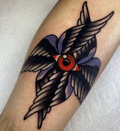 a bird with an eye tattoo on it's arm