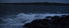 waves crashing on rocks in the ocean at night