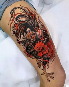 a tattoo on the leg of a man with an orange and black rooster in it