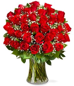 a vase filled with lots of red roses