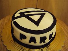 a cake that is sitting on top of a wooden table with the word party written in black and white