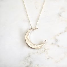 "This unique crescent moon phase pendant is available in silver or 14 k gold. So beautiful polished but equally stunning hand-finished matte, hammered or have it encrusted with diamonds. A focal piece that can be stacked with smaller pendants. It's a slide providing space for a pendant to fit into the opening. We've paired it with our bezel set moonstone. crescent moon 24 millimeters long x 19 mm wide or/ almost 1\" long x 3/4\" wide 14k solid gold or sterling silver pave Diamond encrusted Cresc Anniversary Crescent Jewelry Engraved, Celestial Crescent Engraved Jewelry, Celestial Crescent Jewelry In White Gold, Celestial White Gold Jewelry With Moon Charm, Celestial Moon Phase White Gold Jewelry, Celestial White Gold Moon Phase Jewelry, Celestial Crescent White Gold Jewelry, White Gold Celestial Jewelry With Moon Charm, White Gold Moon Phase Necklace