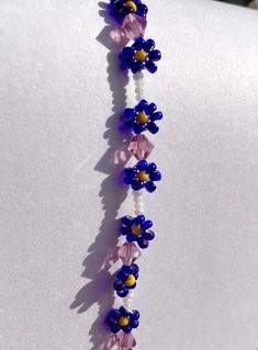 Cute beaded royal blue daisy bracelet with sparkling sweetheart pink beads and pearl white spacers in between Blue Beaded Flower Jewelry, Blue Flower-shaped Jewelry With Spacer Beads, Blue Flower-shaped Jewelry With Beaded Chain, Blue Flower-shaped Beaded Jewelry, Blue Flower-shaped Beaded Necklace With Tiny Beads, Blue Jewelry With Flower Charm And Round Beads, Blue Flower Beaded Bracelets For Summer, Bond Paper Design, Daisy Bracelet