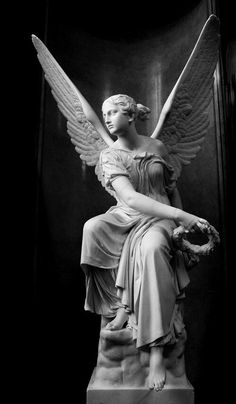 a statue of an angel sitting on top of a marble pedestal in a dark room