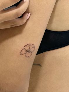 a close up of a person's stomach with a flower tattoo on her left side