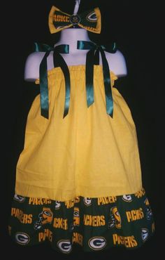 "NFL GREEN BAY PACKERS PILLOWCASE DRESS & MATCHING BOW Dress made out of yellow cotton fabric and layered with licensed Green Bay Packers cotton fabric. Tied with matching satin ribbon and treated with fray check. Bow measures 6\" x 3.5\" and has a bottle cap icon with an alligator clip. This is not an authentic NFL product, however it is made from licensed fabric. I am not affiliated with or sponsored by any sports team. This dress will grow with your little girl and go through all seasons. Whe Green Cotton Dress With Ruffles, Yellow Cotton Dresses With Ruffles, Yellow Cotton Dress With Ruffles, Fitted Mustard Cotton Dress, Mustard Fitted Cotton Dress, Football Dress, Green Bay Packers Sweatshirt, Packers Gear, Fabric Hair Bow