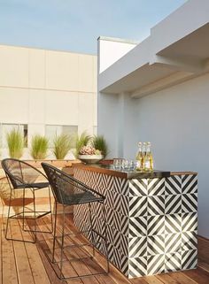 an outdoor bar on a deck with two chairs