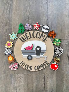 a wooden sign that says welcome to your camper with lots of magnets on it