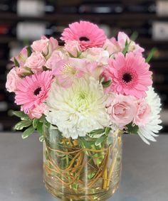 a glass vase filled with pink and white flowers