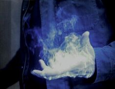 a person holding something in their hand that is glowing blue