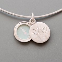 This small sterling silver photo locket, with two hearts, that can hold your favourite photo or a secret love message is more than just a piece of jewelry -- it is a symbol of love, friendship, and shared memories.  Its elegant and timeless design makes it a perfect gift for Valentine's Day, but this locket is equally meaningful as an anniversary gift, a thoughtful birthday present, or a unique way to say "I love you" any day of the year.  So, if you want to celebrate the love, friendship and co White Gold Double Heart Locket Necklace In Sterling Silver, Double Heart Locket Necklace For Anniversary, Sterling Silver Heart Pendant Locket For Wedding, Silver Double Heart Locket Necklace For Keepsake, Personalized Double Heart Sterling Silver Locket Necklace, Sterling Silver Heart Charm Locket For Anniversary, Sterling Silver Double Heart Locket Necklace For Anniversary, Silver Sterling Double Heart Locket Necklace, Sterling Silver Heart Charm Locket Necklace For Wedding