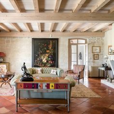 a living room filled with furniture and a painting on the wall