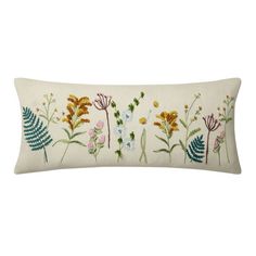 an embroidered pillow with flowers and leaves on the front, along with a white background