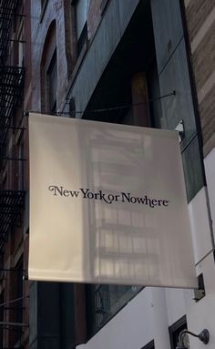 a sign hanging from the side of a building that says new york nowhere on it