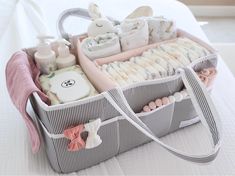 a bag with baby items in it sitting on top of a white bed next to a pillow