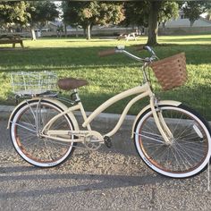 a white bicycle parked on the side of a road next to a park with trees