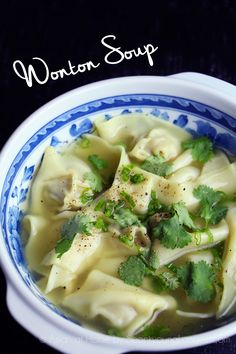 a blue and white bowl filled with dumplings topped with cilantro