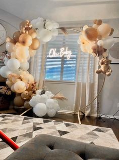 balloons are floating in the air above a living room area with a couch and large window