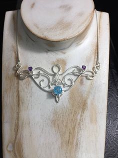 I love Victorian and Renaissance style statement necklaces with a magical and timeless flair, and I hope I've captured it within this piece! I shall fabricate for you this gorgeous Elvish/Renaissance style necklace, in sterling silver, with a center 8mm Blue Topaz and two side 4mm Amethyst gemstones. The center gemstone is 8mm round and the two sides are 4mm round. The chain will be soldered to each side and I will use a 1.2mm thick sterling box chain with a lobster claw clasp for added straight Enchanting Silver Necklace, Magical Silver Pendant Necklace, Spiritual Necklace With Sterling Silver Clasp As Gift, Magical Sterling Silver Pendant Jewelry, Magical Sterling Silver Necklace As A Gift, Unique Jewelry With Sterling Silver Clasp For Gift, Unique Sterling Silver Clasp Jewelry As A Gift, Artisan Sterling Silver Necklace For Gift, Unique Jewelry Gift With Sterling Silver Clasp