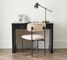 a desk with a chair and a lamp on it