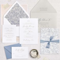 an assortment of wedding stationery items including a ring, envelope and card with ribbon