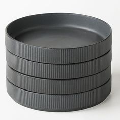 a stack of black plates sitting on top of each other