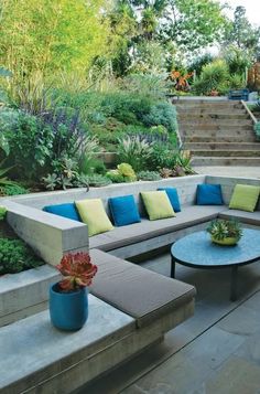 an outdoor seating area with blue and green pillows