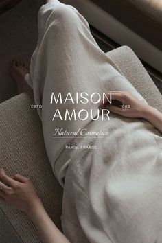 a woman laying on top of a couch next to a window with the words maison amour