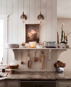 a kitchen counter with plates and utensils hanging on the wall next to it