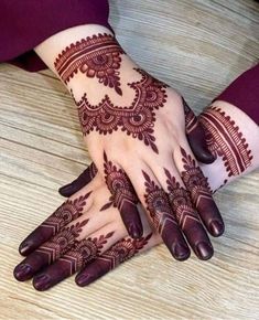 two hands with henna tattoos on them