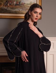 Step into sophistication with this beautifully designed black abaya, featuring intricate embellishments along the sleeves and edges. Crafted for the modern woman who values elegance and modesty, this abaya is perfect for special occasions or adding a touch of luxury to your everyday attire. The flowing silhouette ensures comfort while the embellished details provide a touch of glamour. Whether you're attending a formal event or looking to elevate your modest wardrobe, this abaya offers the perfe Formal Long Sleeve Embellished Kaftan, Embellished Long Sleeve Thobe For Eid, Elegant Kaftan With Bell Sleeves, Embellished Abaya For Evening And Eid, Elegant Festive Kaftan With Embroidered Sleeves, Elegant Long Sleeve Festive Thobe, Festive Elegant Long Sleeve Thobe, Elegant Long Sleeve Kaftan For Eid, Luxury Long Sleeve Kaftan For Evening